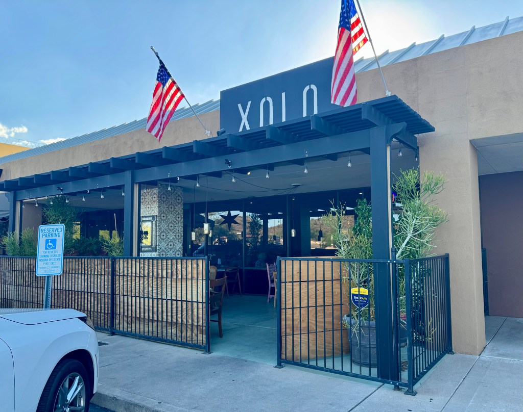 Two American flags, gifted by a customer, hang over Xolo's patio.