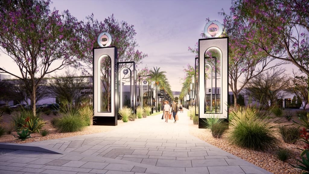 A tree-lined sidewalk with large pillars on each side.