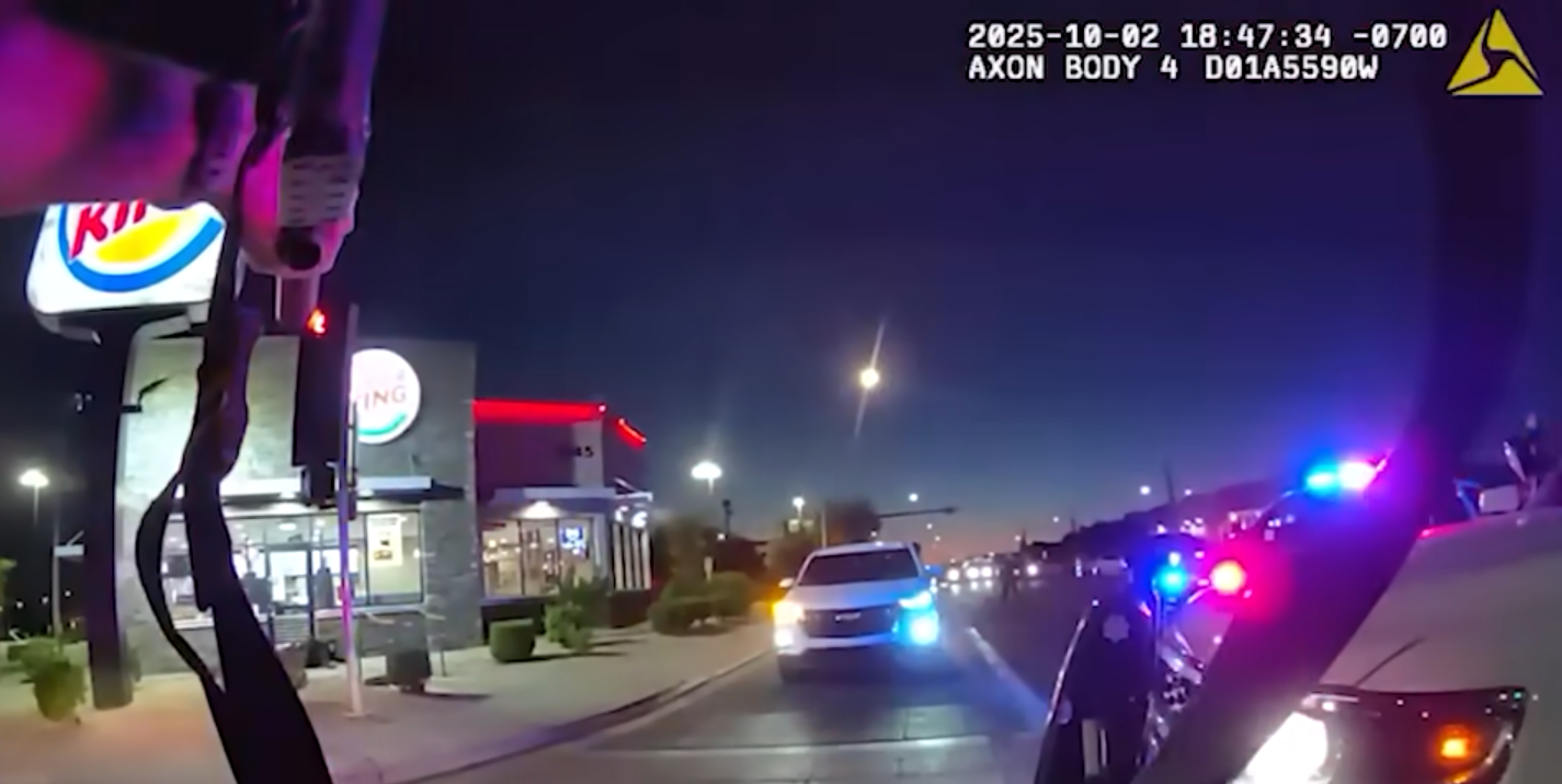 body cam footage showing someone pointing a rifle at a man on the ground in front of a burger king at night