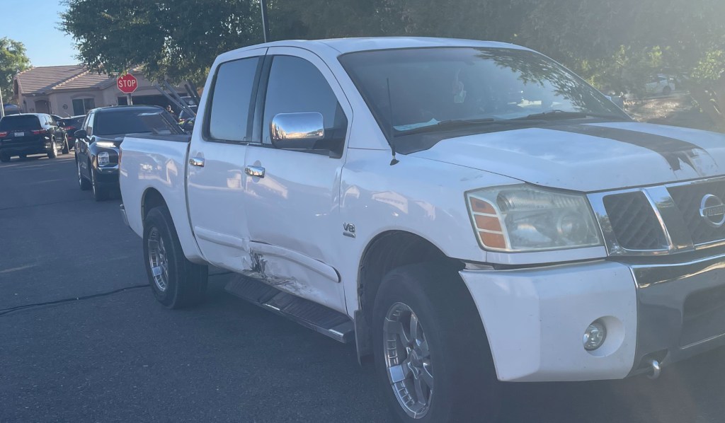 a white truck with a dent in the passenger side