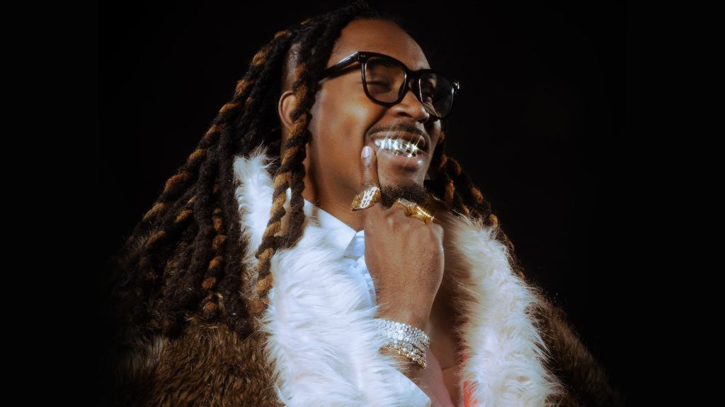 An African-american male with gold teeth in a fur coat.