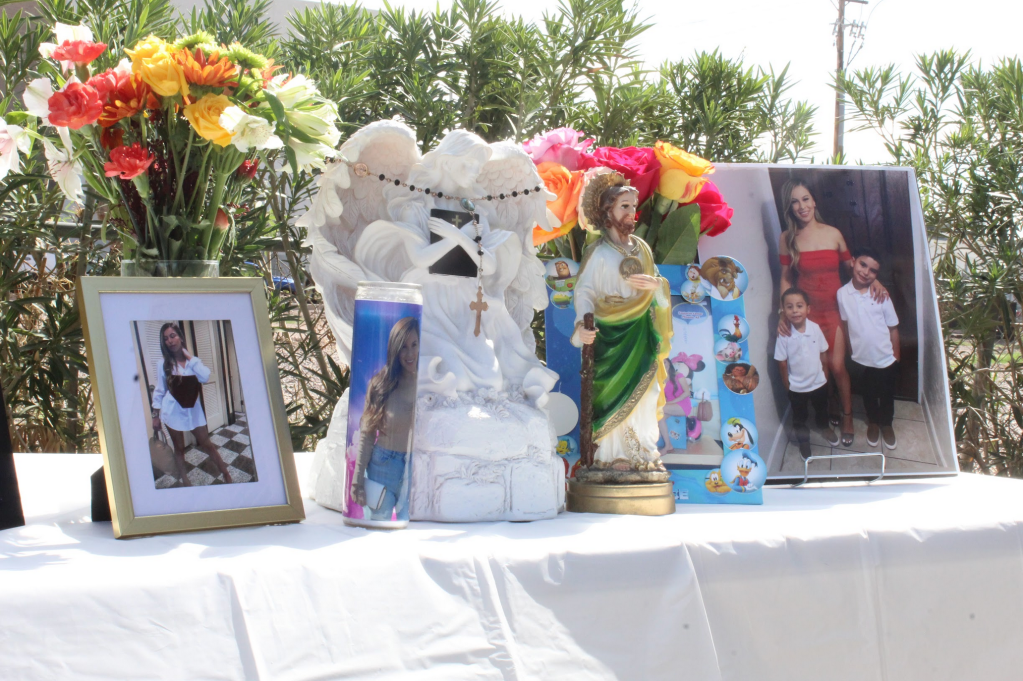 a table, with vases of flowers and family photos