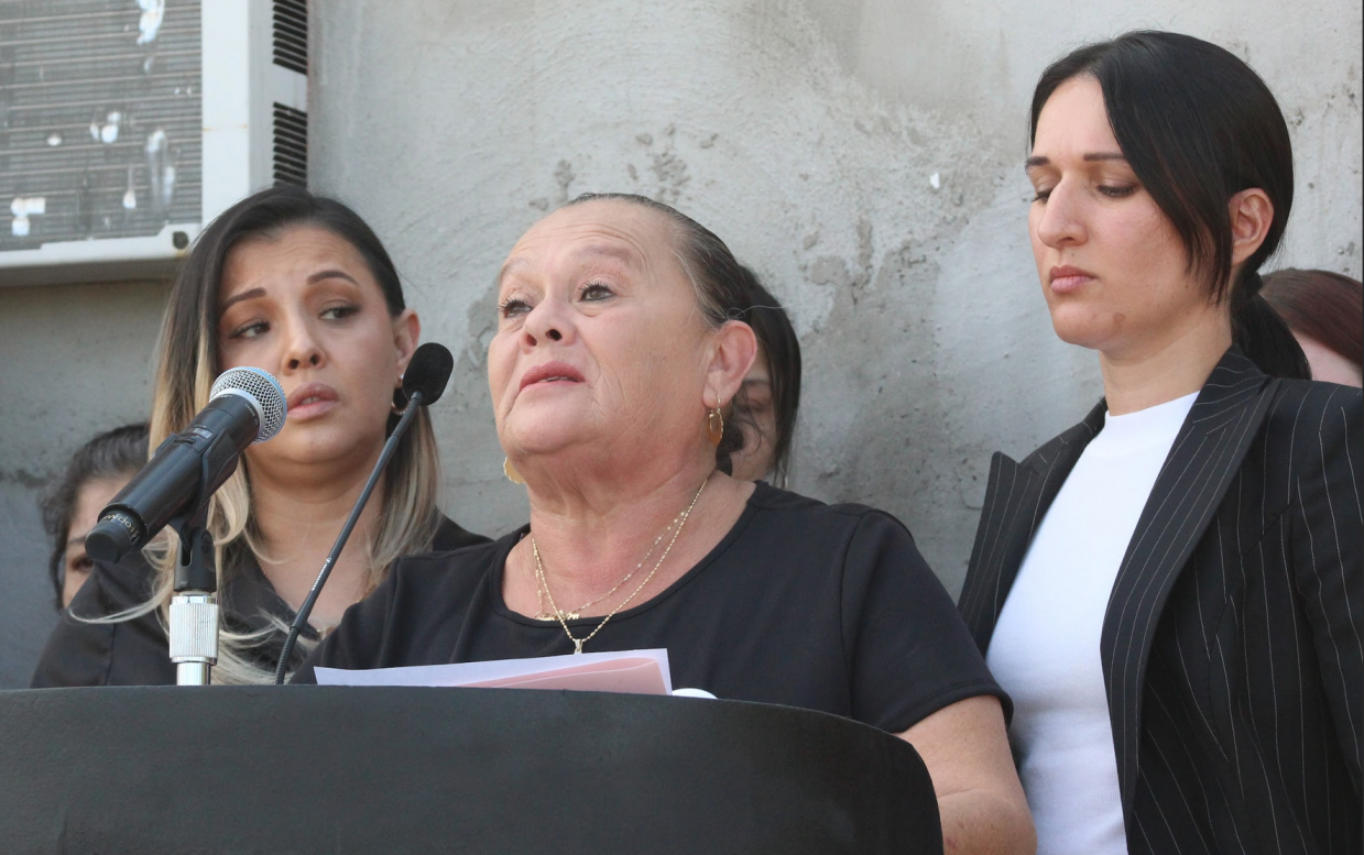 a woman appears to cry while speaking into a microphone