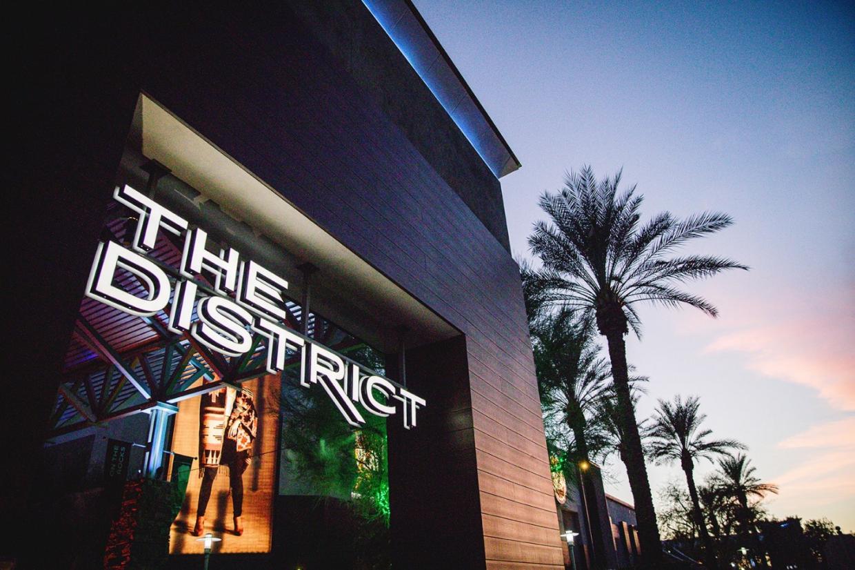 a building with a sign reading the district stands against an open sky