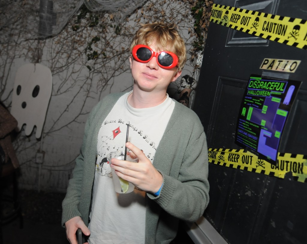 A young adult male dressed as Kurt Cobain of Nirvana.