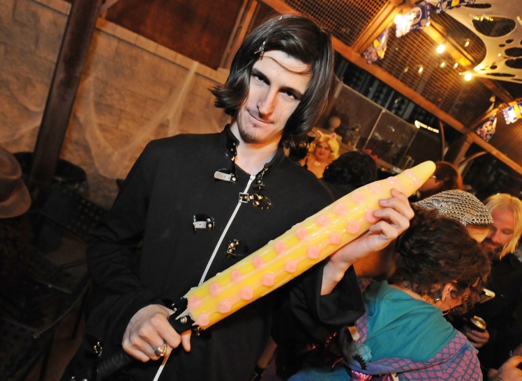A man dressed in black holding a tentacle-shaped paddle.