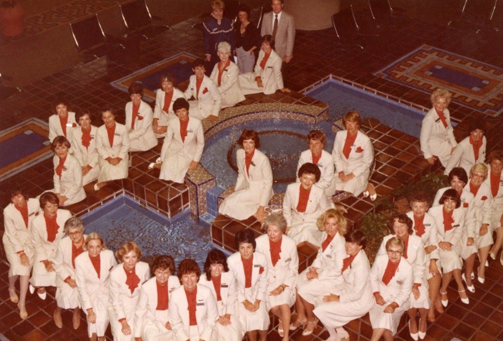 A large group of women gathered around a fountain.