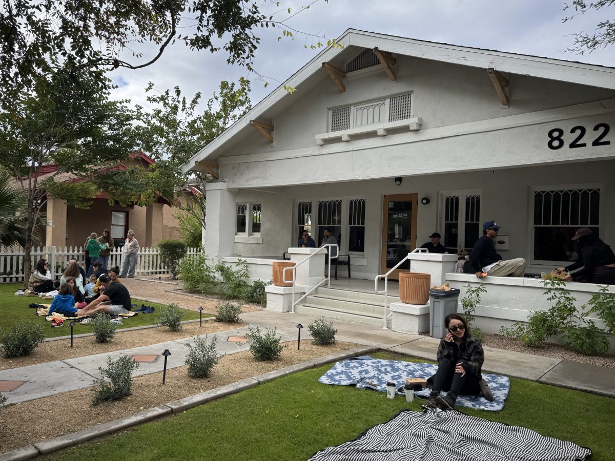 People lounging on a lawn of a bungalow house in Phoenix.