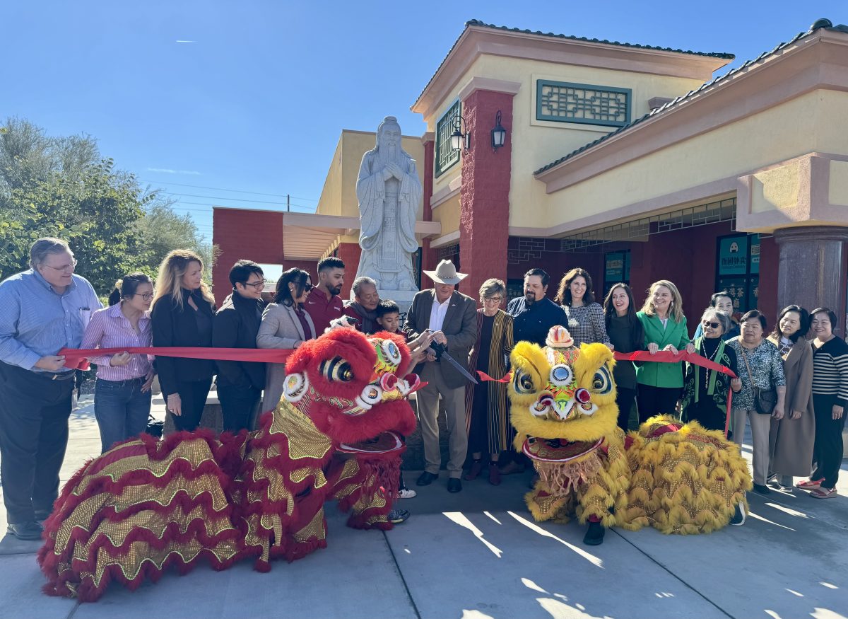 A group stands at a ribbon cutting.
