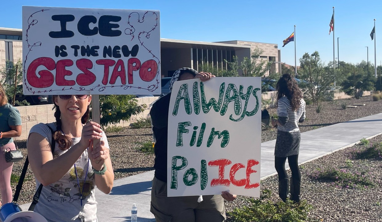 protesters hold signs that say "ICE is the new Gestapo" and "always film police"