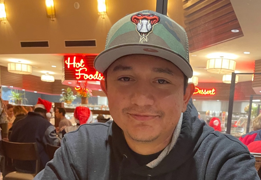 a hispanic man in a diamondbacks hat