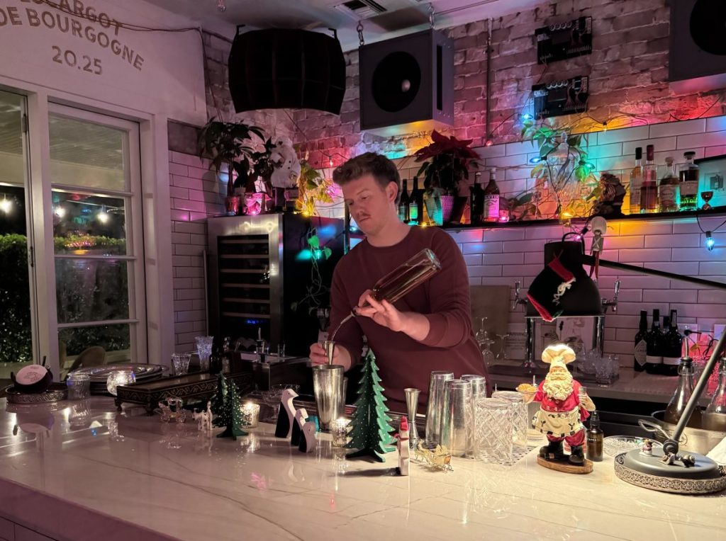 A bartender measuring out a spirit into a jigger.