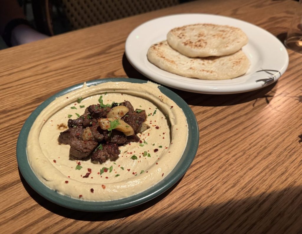 A plate of hummus and pitas.
