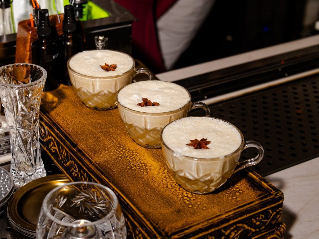Three cocktails in glass teacups.