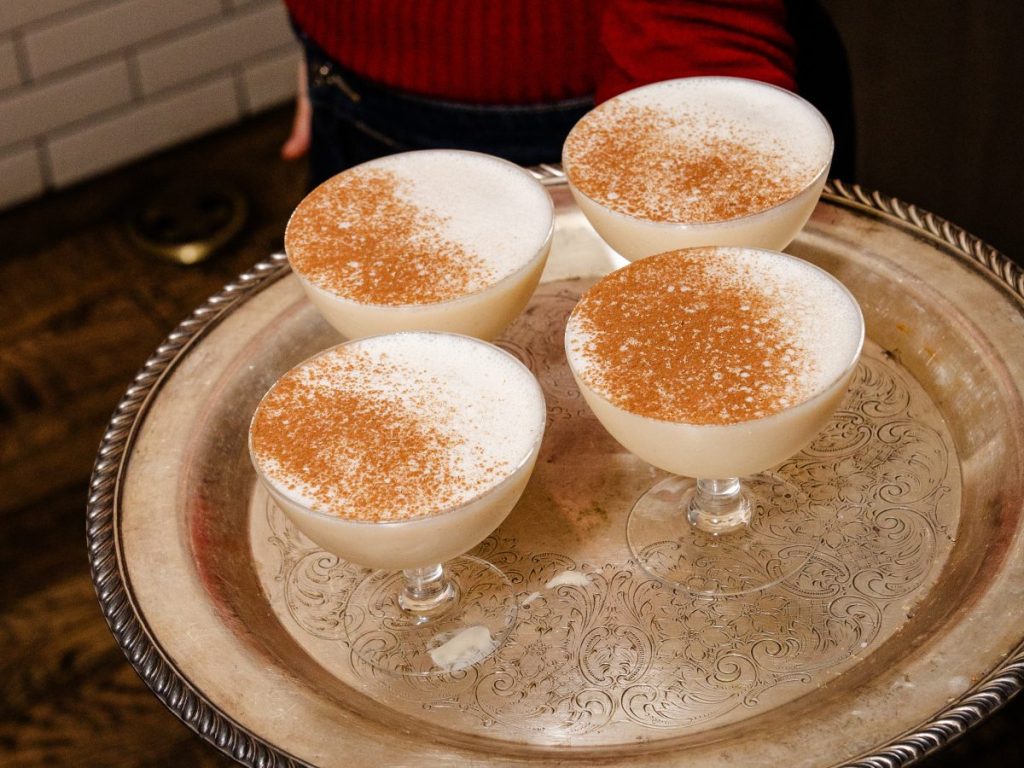 A tray with four cocktails in coupes.