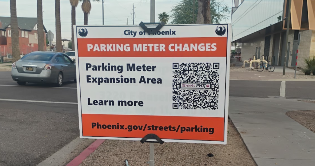 a sign warning that parking meters will be coming to a downtown phoenix street