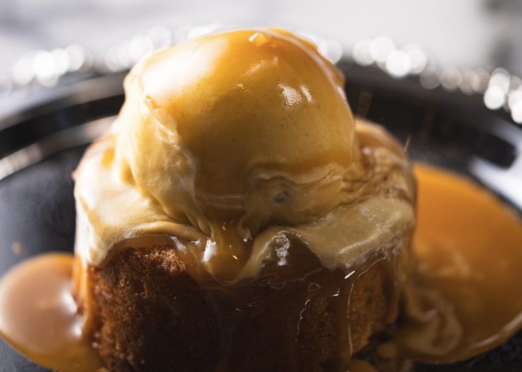A plated dessert with cake and a scoop of ice cream.