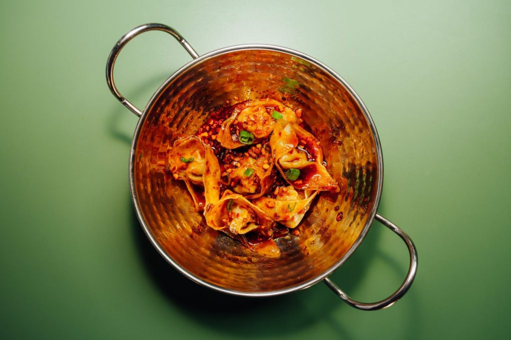 A bowl of wontons in spicy chili sauce.