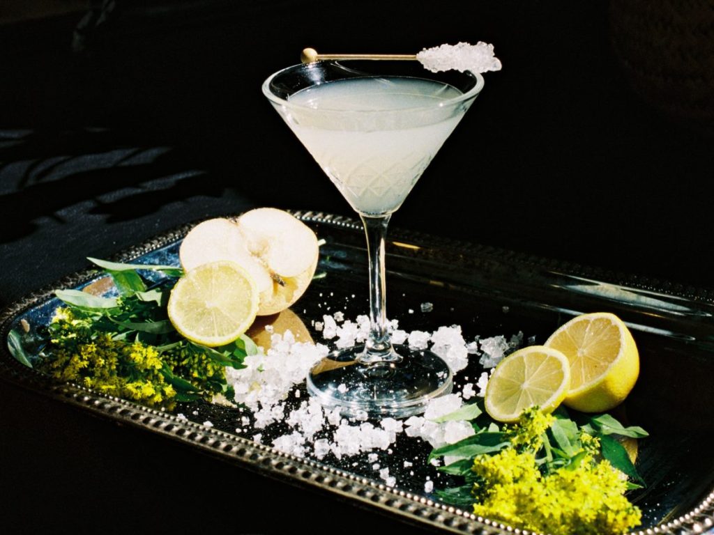 A cocktail on a tray with its ingredients.