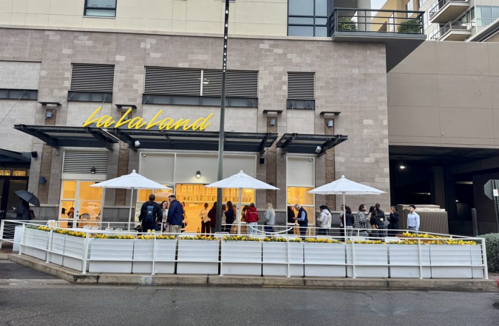 People wait in line outside a cafe in Kierland Commons.