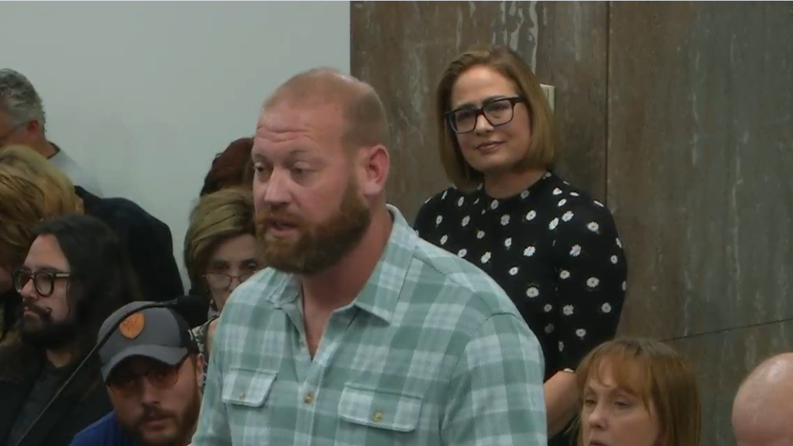 kyrsten sinema watches a man testify at the arizona legislature