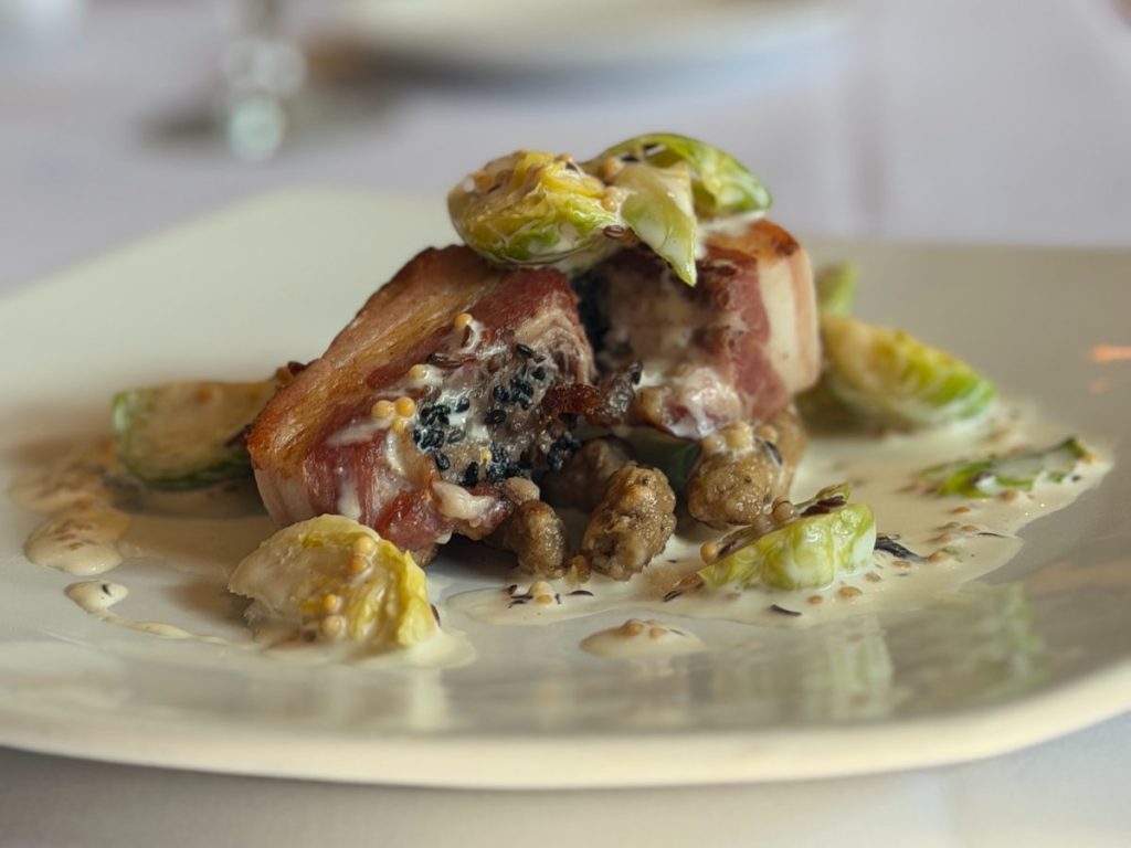 A plate of pork belly, Brussels sprouts and spaetzle.
