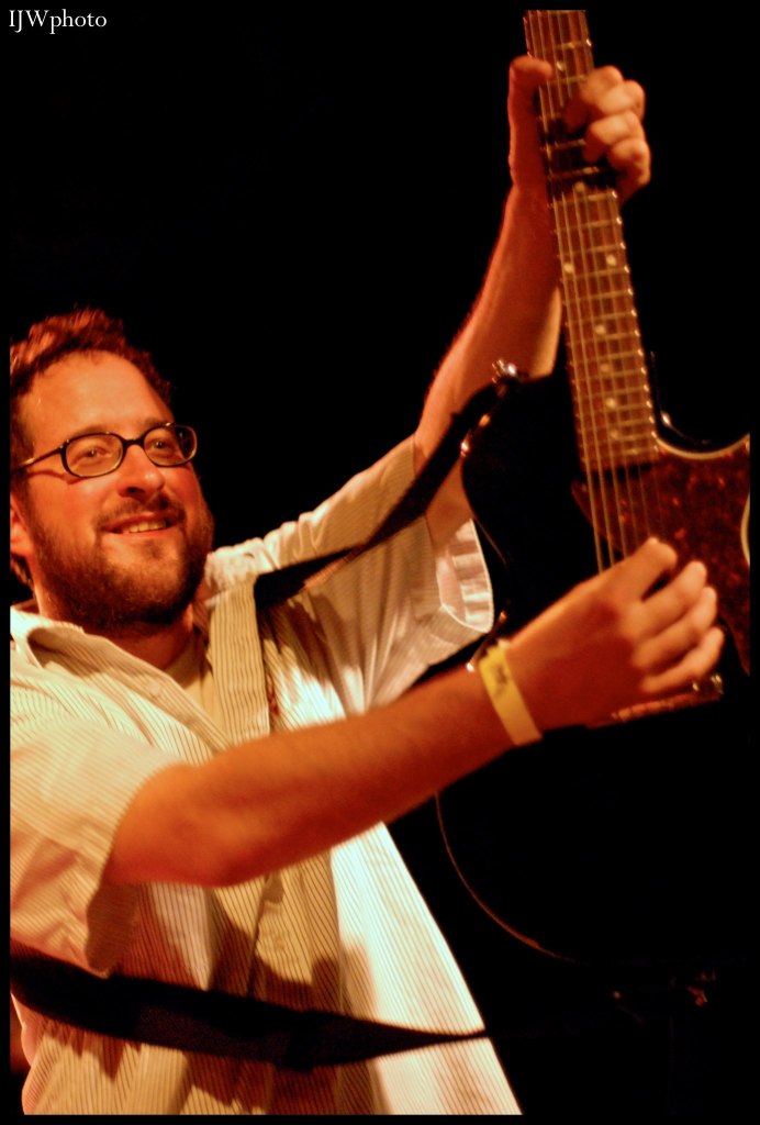 Craig Finn from The Hold Steady holds up a guitar.