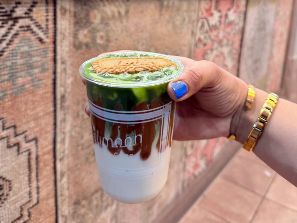 An iced matcha latte topped with a cookie