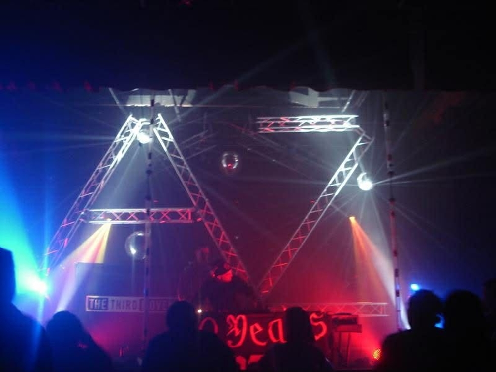 The stage at a rave in the 2000s with the letters AZ spelled out with metal girders.