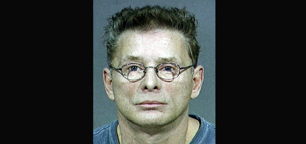 a mugshot of a man in glasses