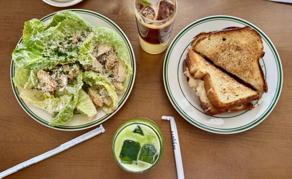 An overhead view of a coffee, matcha latte, salad and grilled cheese from Matilda's.
