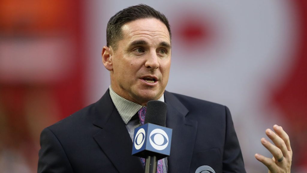 jay feely in a suit holding a CBS microphone
