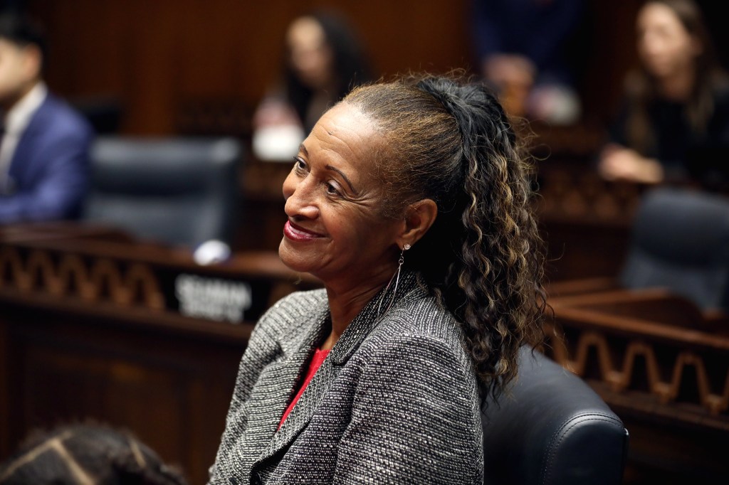 a woman in a gray blazer and a ponytail