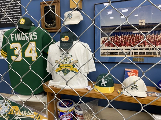 Oakland Athletics display featuring memorabilia from pitcher Rollie Fingers behind a chain-link fence.