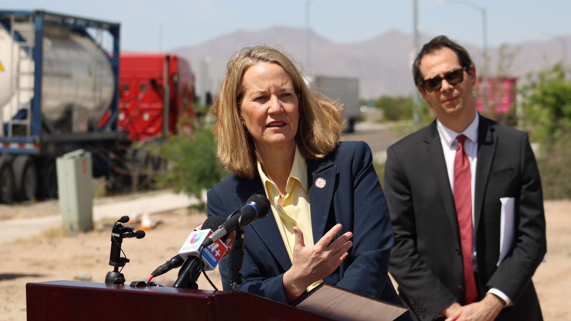 kris mayes speaks at a podium outdoors