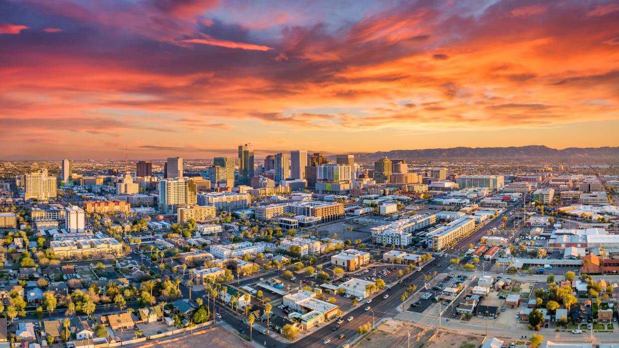 the downtown phoenix skyline at dusk, with the clouds tinted orange