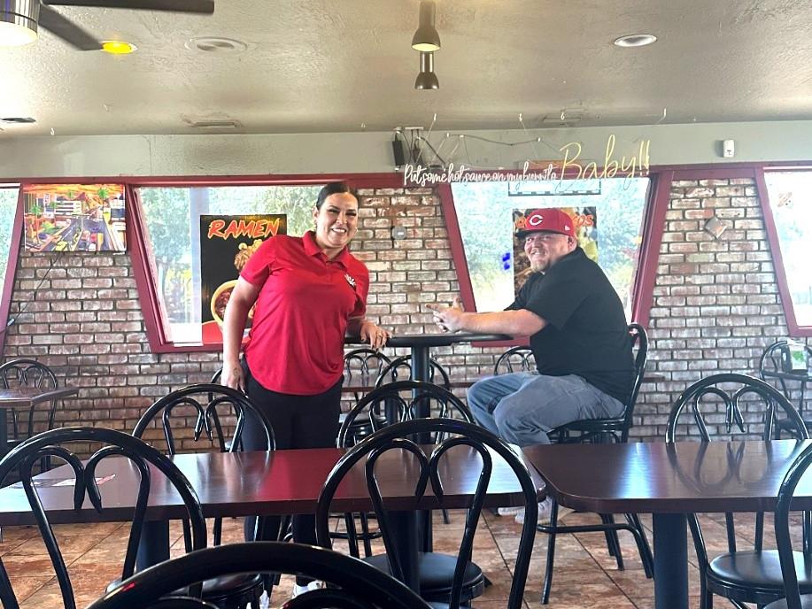 The owners of AZ Taco King at a table inside their Phoenix restaurant.
