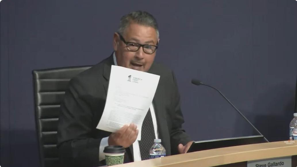 Steve Gallardo holds up a letter during a meeting