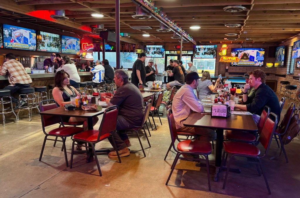 People sit at the bar and in the dining room of Pinky's.