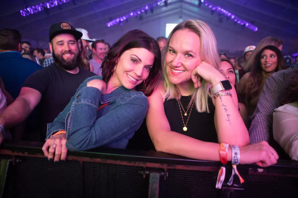 Fans smile for the camera while watching a concert from the front of the crowd at the Coors Light Birds Nest.