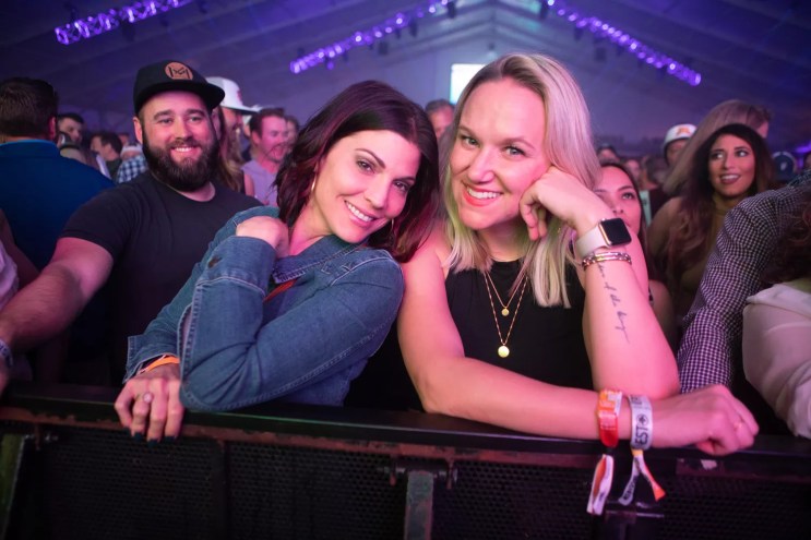 Fans smile for the camera while watching a concert from the front of the crowd at the Coors Light Birds Nest.