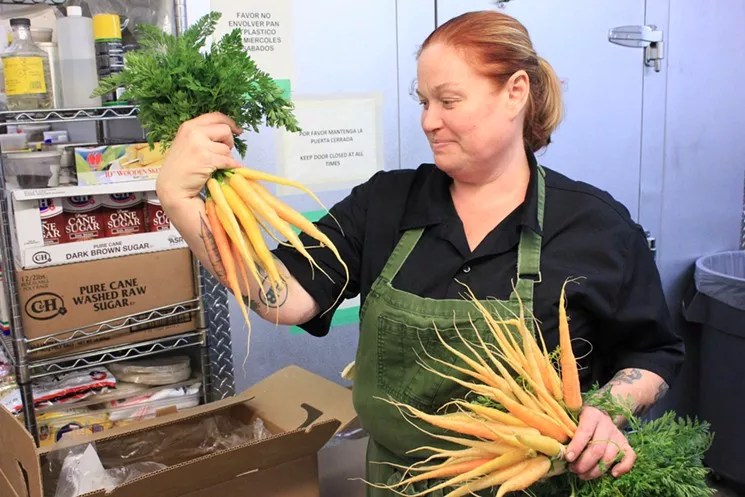 Chef Charleen Badman holding carrots.