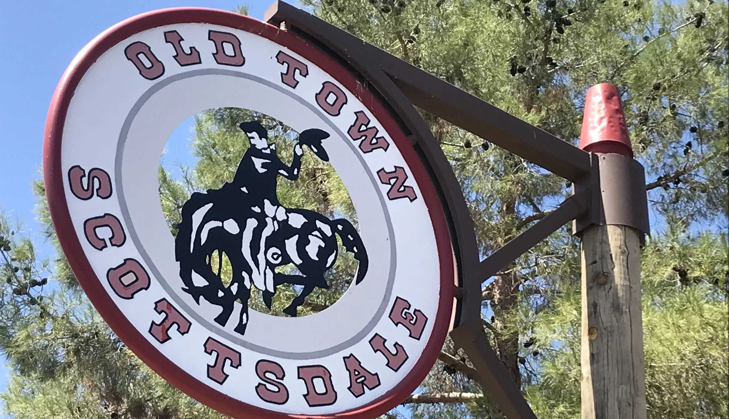 a round sign for old town scottsdale showing a cowboy on a bucking horse