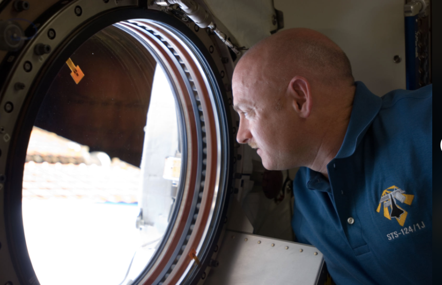 astronaut mark kelly peers out a window of a ship
