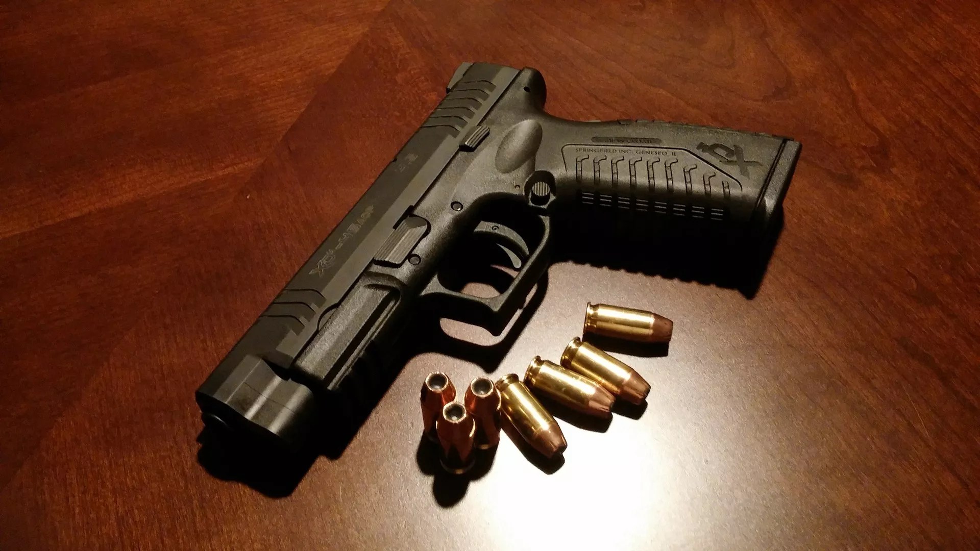A handgun with bullets laid out around it.
