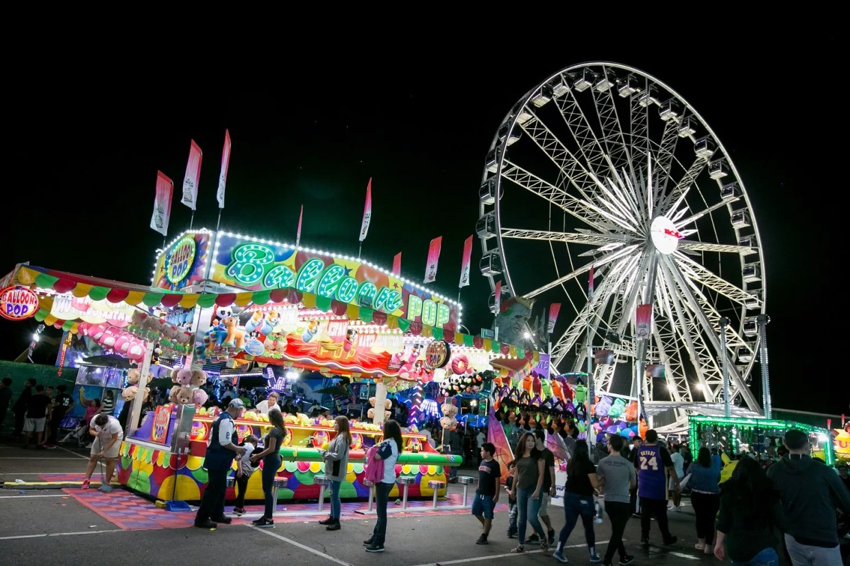 A carnival with rides and food at nighttime.