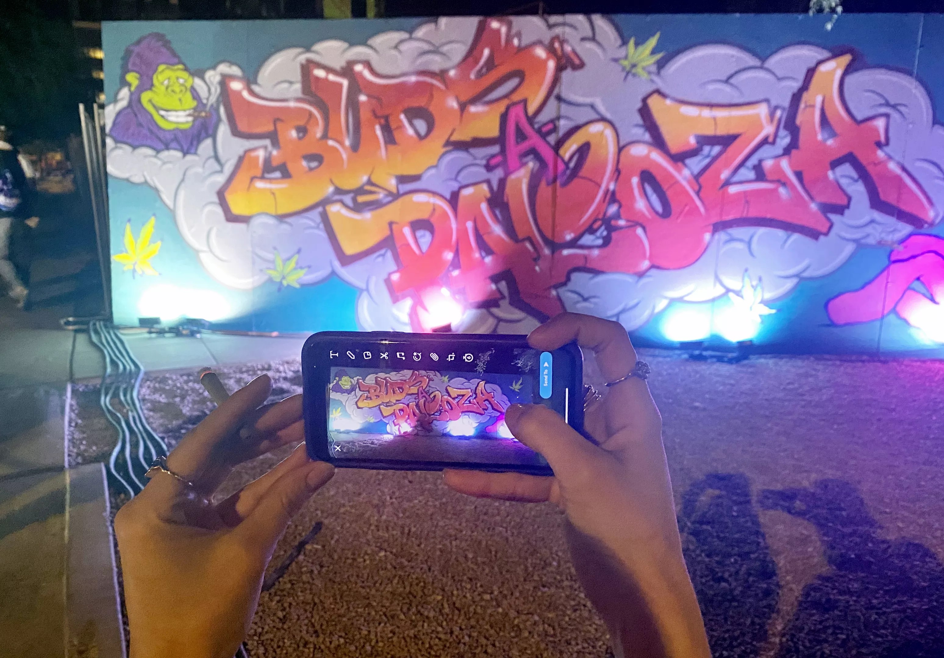 a phone takes a picture of buds-a-palooza graffiti