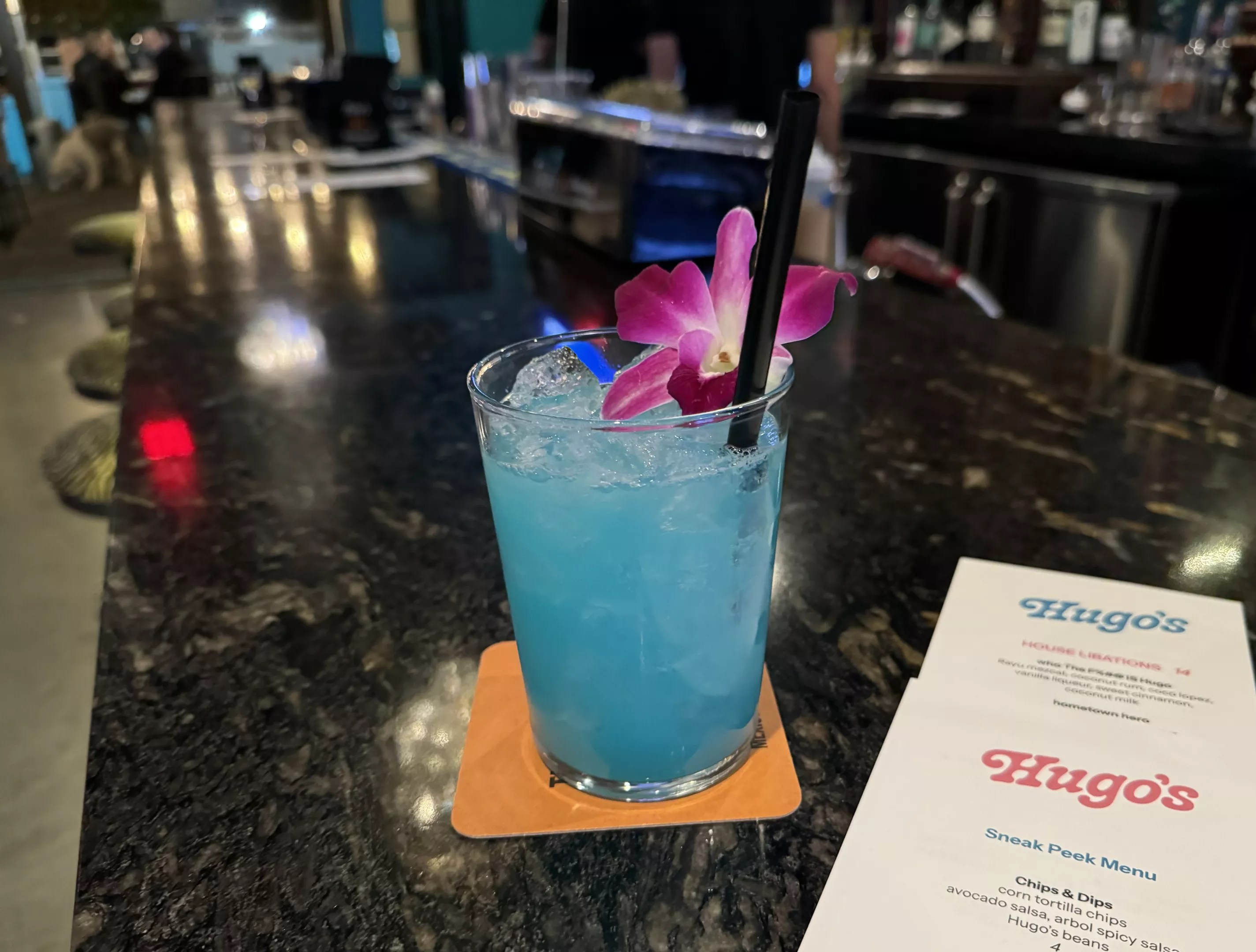 Blue cocktail and menu at Hugo's Cantina.