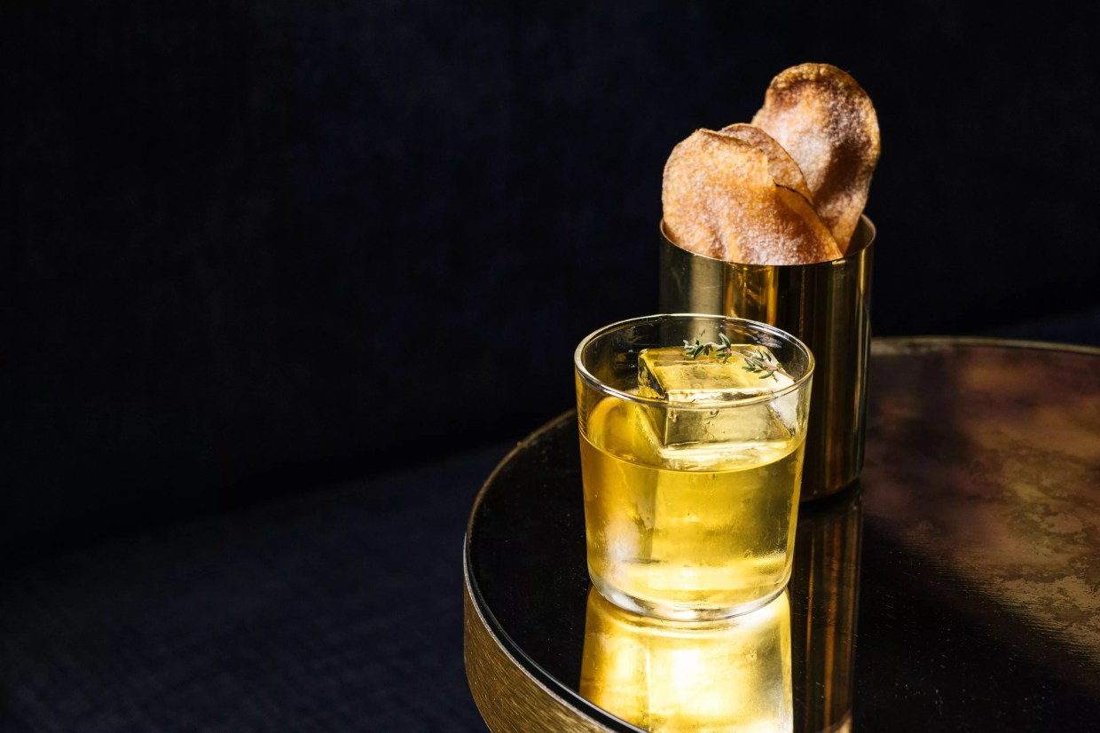 A Platform 18 cocktail and side of potato chips.