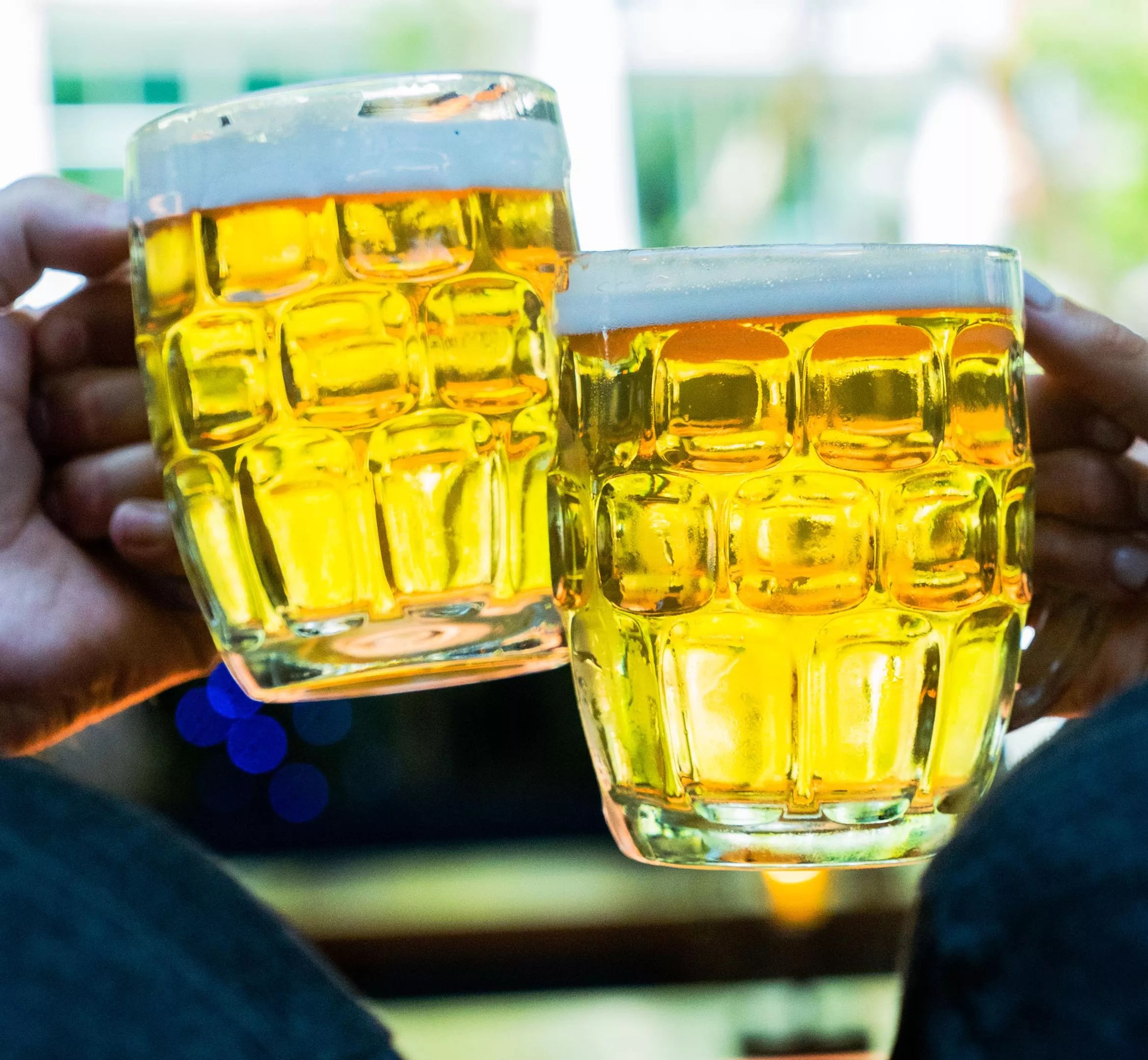 Clinking two beer mugs.